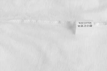 Clothing label with care information on white garment, space for text