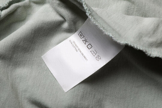 Clothing label on pale olive garment, closeup