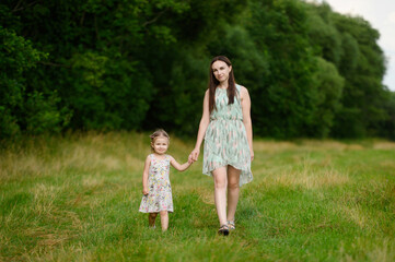 Portraits of joyful mother and daughter spend time together, enjoy happy family time, walk in the park. Mother's day.