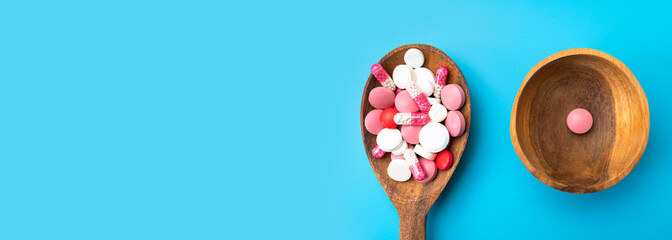 Concept of medicine, health care, pharmaceuticals. Pink and white tablets, pills, capsules,...