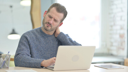 Middle Aged Man having Neck Pain while using Laptop