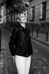 Fototapeta premium A woman wearing a black leather jacket and sunglasses smiles.