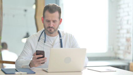 Doctor using Smartphone at Work in Clinic