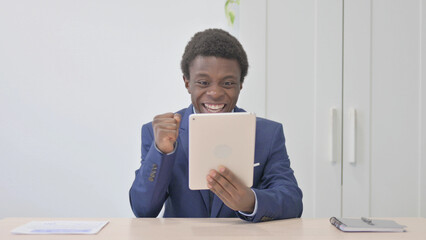 Young African Businessman Cheering Win on Digital Tablet