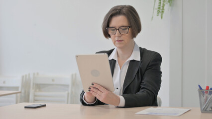 Old Businesswoman using Digital Tablet for Work