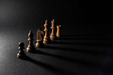 Chess pawns in a row with shadows on a black background. Strategy concept, success concept, hierarchy concept, teamwork concept. Social ladder, corporate ladder.