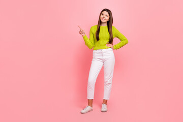 Fototapeta na wymiar Full body photo of lovely teen lady point look interested empty space dressed stylish green clothes isolated on pink color background