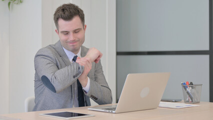 Naklejka premium Young Businessman with Wrist Pain Working on Laptop