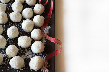 Raffaello, caramelle rotonde fatte in casa a base di cocco e cioccolato bianco in un piatto di...