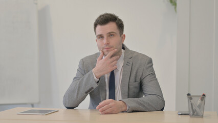 Naklejka premium Pensive Young Businessman Thinking while Sitting at Work