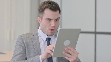 Portrait of Young Businessman Upset by Loss on Tablet