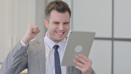 Portrait of Young Businessman Celebrating Win on Tablet