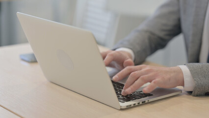 Close up of Young Businessman Typing on Laptop