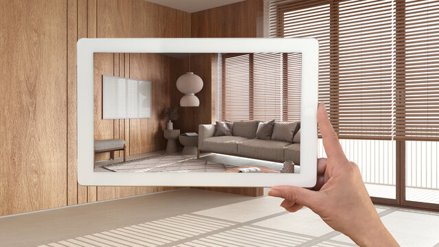 Augmented Reality Concept. Hand Holding Tablet With AR Application Used To Simulate Furniture And Design Products In Empty Wooden Interior With Marble Floor, Japandi Living Room