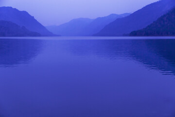 Lake Teletskoye, Altai Republic, Russia. Blue clear sky and Mirror of lake. Abstract panoramic landscape with natural gradient blue color, nature environment scene, monochrome background