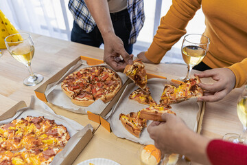 Group of employees eating Italian pizza Hand picked pizza in a lunch or dinner shop. Tasty seafood gravy sauce. Traditional Italian fast food on wooden table with drinking wine.