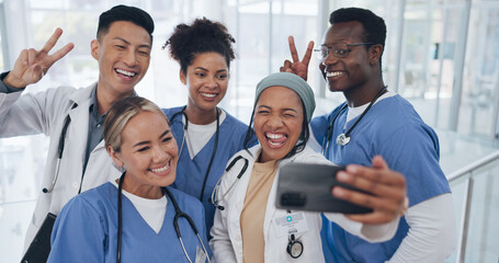 Fototapeta na wymiar Doctors, team and selfie with diversity and health group, happiness with collaboration and smartphone photography. Medical professional, happy in picture and people in medicine with peace hand sign