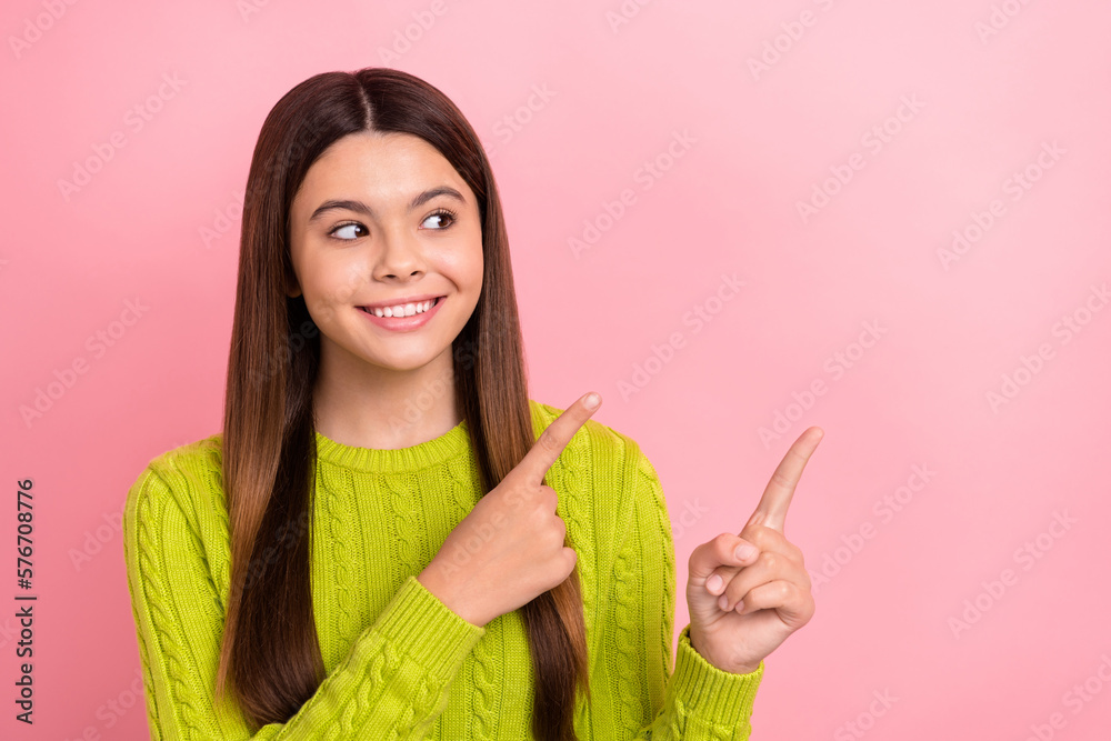 Poster Photo of cheerful sweet girl beaming smile look indicate fingers empty space isolated on pink color background