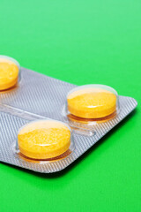 Yellow pills on a bright green background