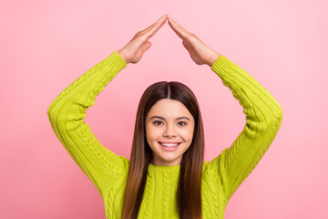 Obraz na płótnie Canvas Portrait of positive sweet girl toothy smile arms show house roof gesture above head isolated on pink color background