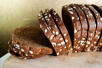 Healthy sliced bread on rustic wooden board, seed bread source of energy, carbohydrates and fiber, traditional flavor.