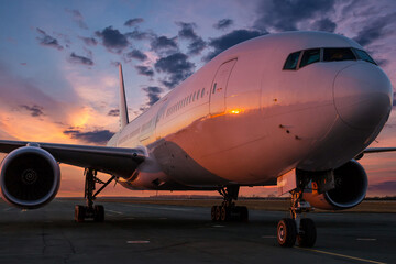 Wide body passenger airliner at the airport apron against the backdrop of a picturesque evening sky