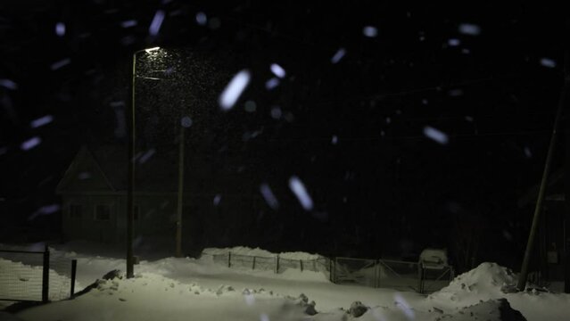  Winter village is littered with snow during night storm.
