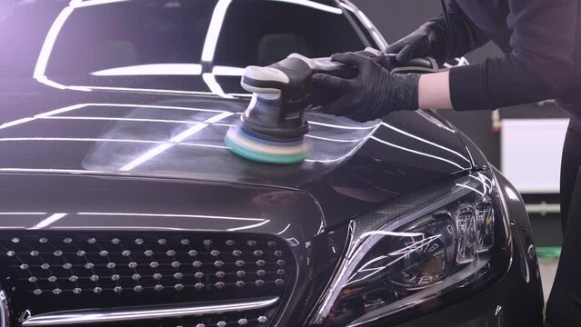 Professional car detailing using machinery and polishers for paint restoration.