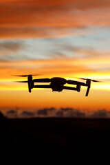 Flying drone in a sunset sky.