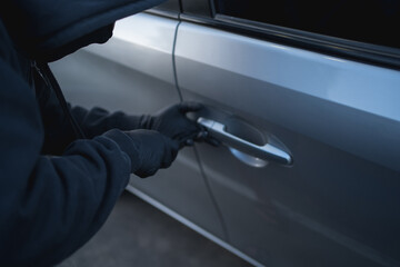 Close-up shot of a thief stealing a car with a screwdriver. car theft concept
