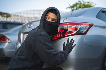Terrorist or car thief in black mask with car. robbery and crime concept.