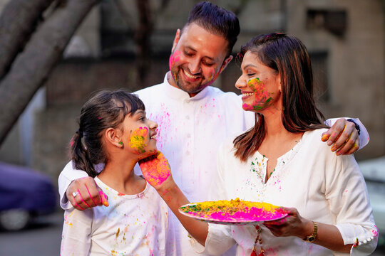 young indian family celebrating holi festival