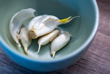 Garlic cloves in small green bowl on countertop