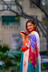 indian young girl showing colourful palm and celebrating holi