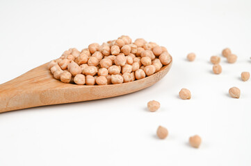 Wooden spoon with chickpeas isolated on white background.