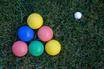 Image of a pyramid of colored bowls in a green field with a ball.
