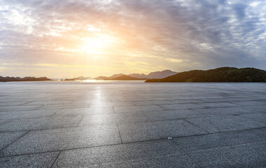 Empty square floor with mountain background at sunset