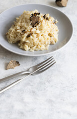 Risotto with porcini mushrooms and black truffles served in a plate top view, gourmet cousine