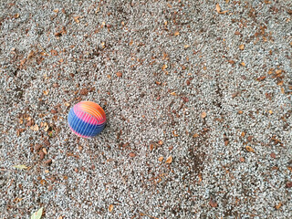 Un pavimento de grava con una pelota de colores
