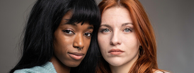 Horizontal banner or header with couple of young women of different ethnicities - Red headed...