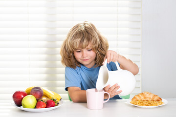 Child eating meal. Kid pouring whole cows milk. Healthy nutrition for children. Cute boy enjoy eating for morning breakfast with appetite. Hungry child eat tasty fruits and vegetables.