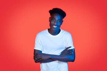 Cheerful cool young african american guy posing in neon light