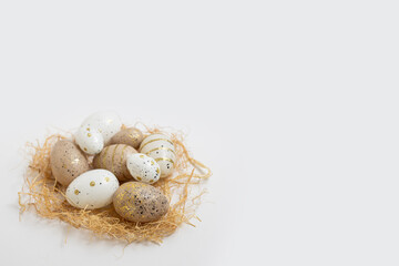 Decorative Easter eggs and straw on a white background