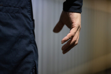 後ろから見た不審な男性の手