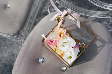 Box with wedding rings for painting newlyweds, decorated with fresh flower petals. Wedding decoration concept 