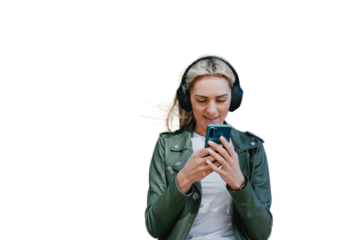 Attractive young blonde Caucasian girl in headphones and leather jacket using phone sends message to boyfriend, listening music. Beautiful Italian hipster female mak video call. transparent background