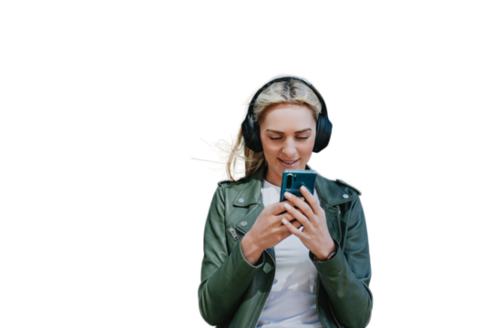 Attractive young blonde Caucasian girl in headphones and leather jacket using phone sends message to boyfriend, listening music. Beautiful Italian hipster female mak video call. transparent background
