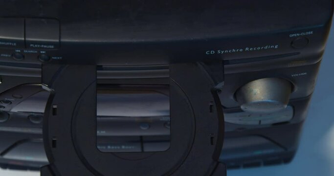 Close-up of a hand putting a disc into the player.