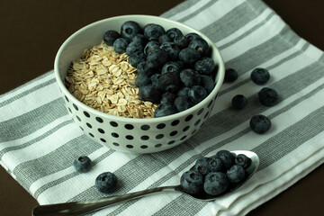 Healthy and healthy breakfast, oatmeal with blueberries on a dark background