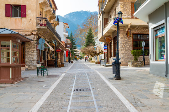 Stone paved street with various of shops and greek taverns in Kalavryta, Peloponnese, Greece
